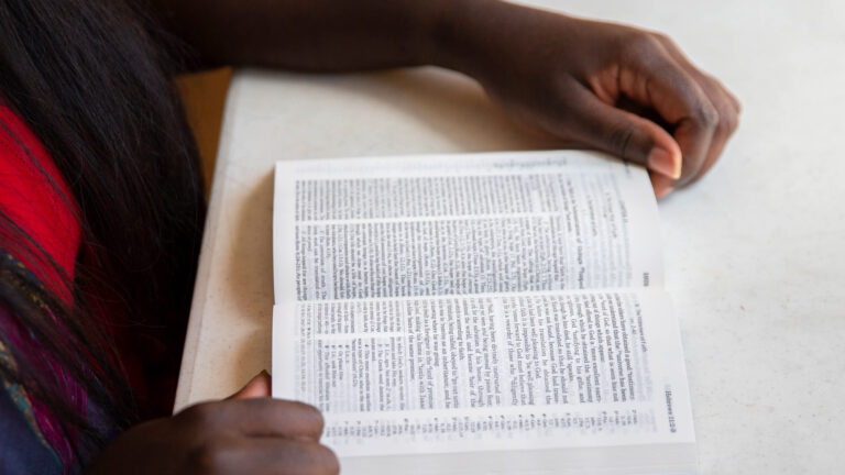 person reading the Bible at a table